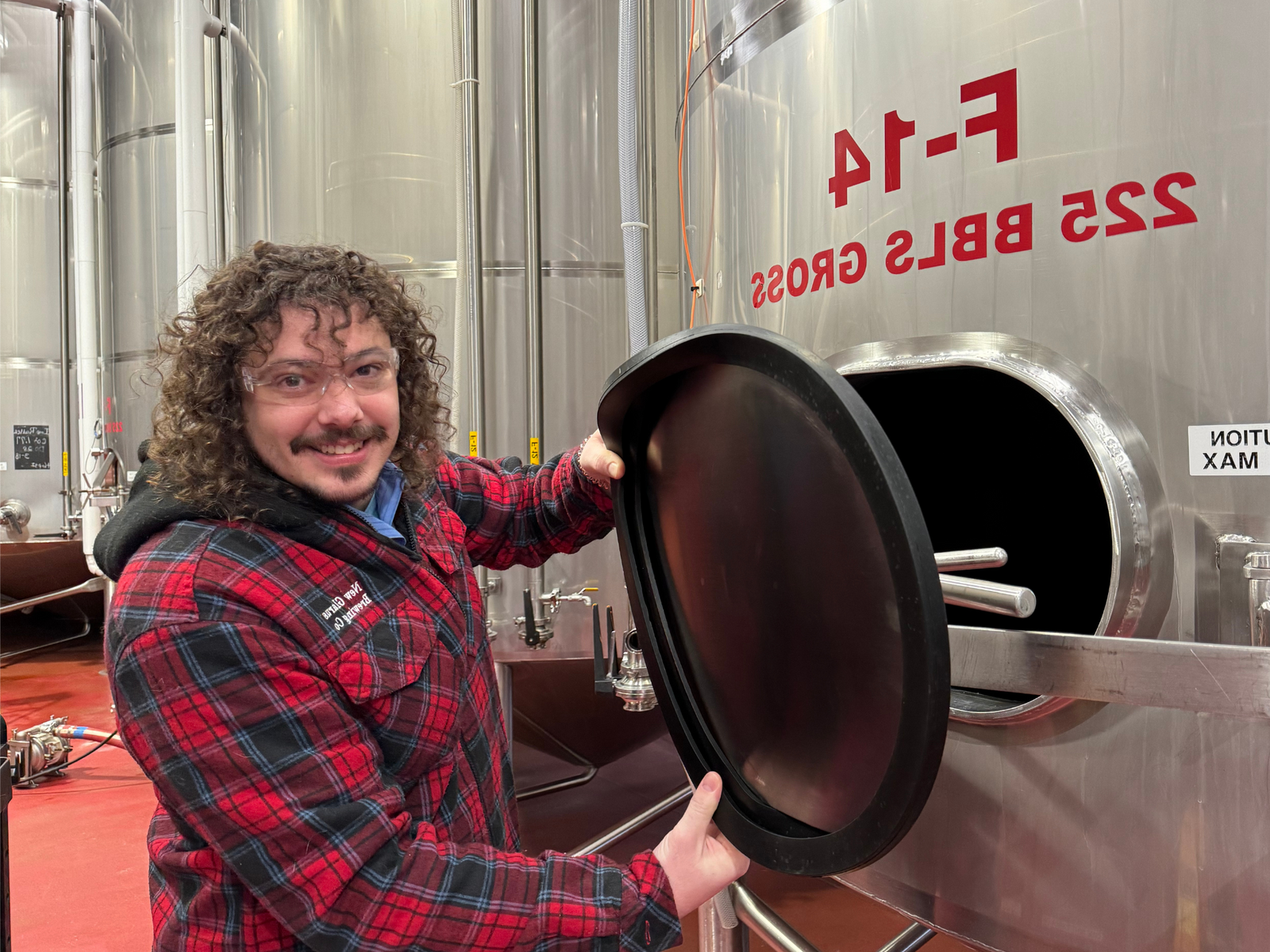 Brewer in front of fermentation tank