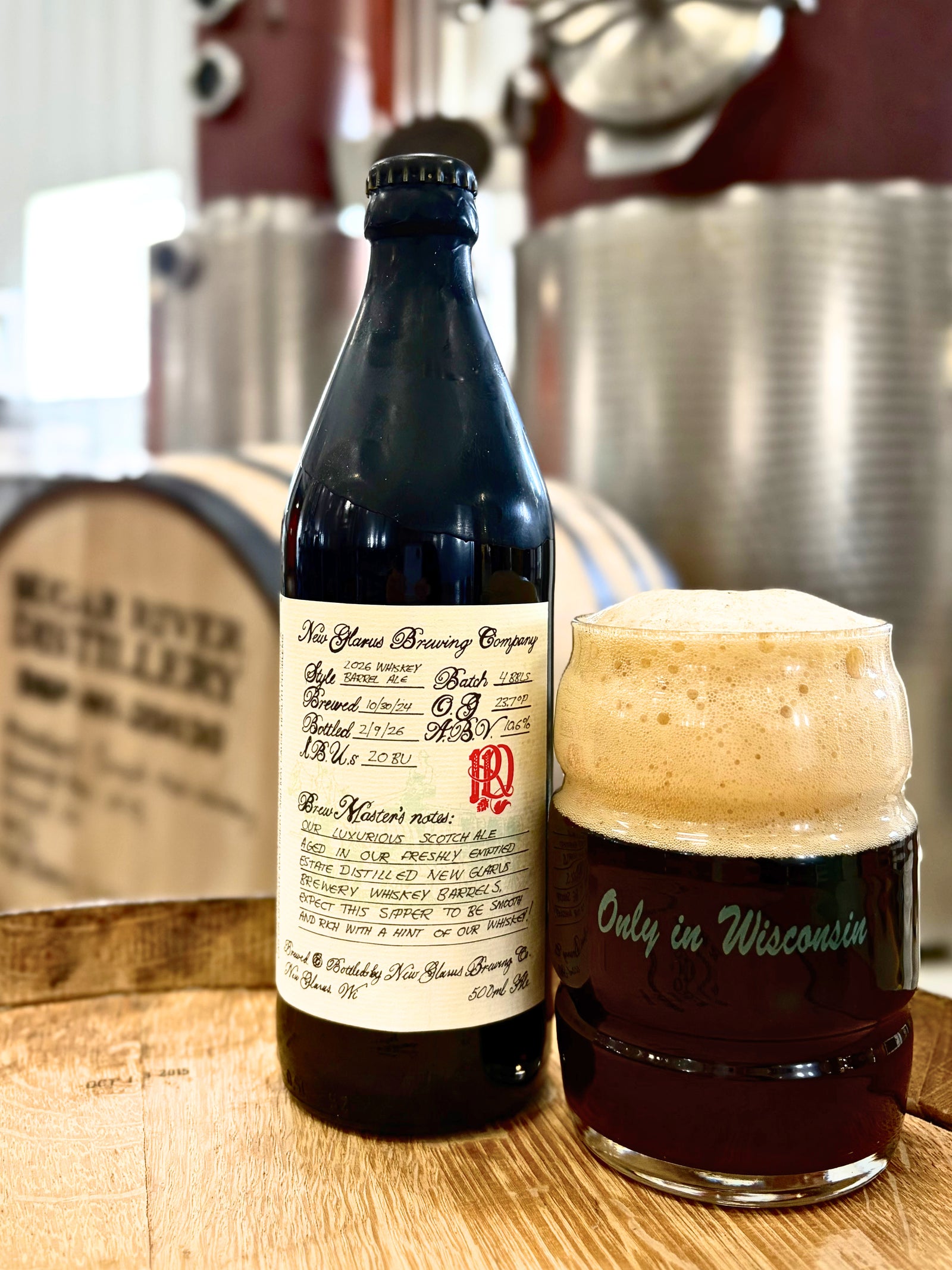 2026 Whiskey Barrel Ale in front of still and wood barrel background.