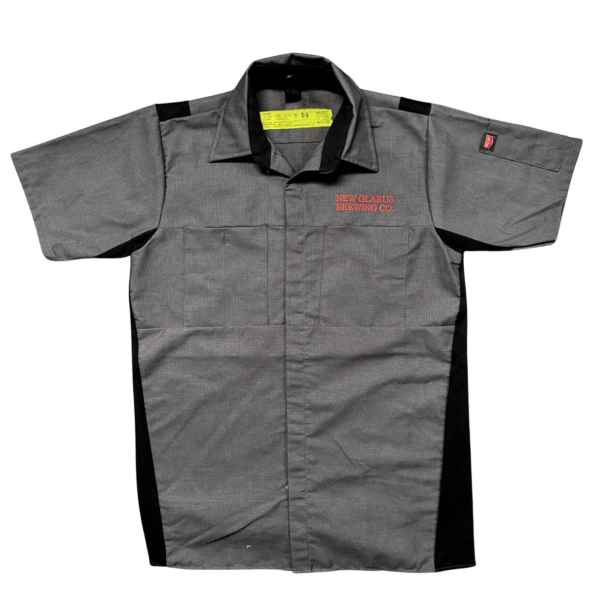  Red Kap Gray button down work shirt, with air flow venaltion down the sides and back of neck.  Pen holder on sleeve, with New Glarus Brewing Co. logo over right pocket in red.